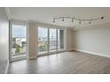 Bright, spacious living room showcasing light wood floors and balcony access with scenic views at 330 Concord St # 7E, Charleston, SC 29401
