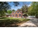 Classic brick residence with a neatly landscaped front yard and a winding driveway, exuding timeless appeal at 3708 Colonel Vanderhorst Cir, Mount Pleasant, SC 29466