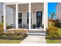 Charming front porch with seating, decorative plants, and a well-maintained lawn at 384 Ripple Park Dr, Summerville, SC 29486