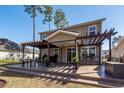 A spacious stamped concrete patio, with a pergola and outdoor seating, is perfect for entertaining and enjoying the outdoors at 505 Kilarney Rd, Summerville, SC 29483