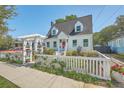 Charming home with a well-manicured lawn, white picket fence, and a decorative pergola at 928 Ashley Ave, Charleston, SC 29403