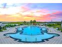 Stunning resort-style pool overlooking the water with lush landscaping and comfortable lounge seating at 102 Tidewater Way, Charleston, SC 29492