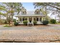 Inviting two-story home with a classic front porch and dormer windows, set on a tree-lined lot at 1034 Orangeburg Rd, Summerville, SC 29483