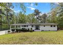 Inviting white brick home featuring a covered porch and well-maintained front lawn at 107 Woodland Dr, Summerville, SC 29485