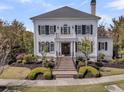 Charming white home with classic black shutters and inviting front entrance with brick steps at 111 Ithecaw Creek St, Charleston, SC 29492