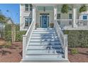 Inviting staircase leading to a charming porch with a vibrant blue ceiling and front door at 1115 Barfield St, Charleston, SC 29492