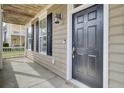 Inviting front porch with dark wood door, black shutters, and elegant lighting at 112 Tin Can Aly, Summerville, SC 29483