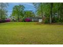 Lovely single story brick home with a green lawn and pink flowering bushes in the front yard at 1121 Inverness Ln, Hanahan, SC 29410