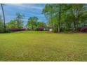 Lovely single story brick home with a green lawn and pink flowering bushes in the front yard at 1121 Inverness Ln, Hanahan, SC 29410