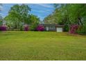 Lovely single story brick home with a green lawn and pink flowering bushes in the front yard at 1121 Inverness Ln, Hanahan, SC 29410