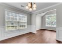 Bright dining room with large windows, wood-look floors, and elegant wainscoting at 1158 Peninsula Cove Dr, Charleston, SC 29492