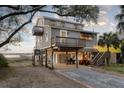Charming stilted home features a spacious outdoor area, boardwalk access, and serene marsh views at 1504 Forrest Ave, Folly Beach, SC 29439