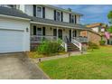 Charming two-story home featuring a welcoming front porch and well-maintained lawn with a two car garage at 184 Ponderosa Dr, Ladson, SC 29456