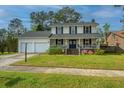 Charming two-story home featuring a welcoming front porch and well-maintained lawn with a two car garage at 184 Ponderosa Dr, Ladson, SC 29456