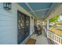 Inviting front porch featuring rocking chairs, stylish lighting, and attractive double doors with leaded glass insets at 184 Ponderosa Dr, Ladson, SC 29456
