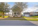 Attractive two-story home with front porch and a detached garage with a basketball hoop, surrounded by green lawns at 2107 Military Way, Charleston, SC 29414