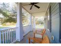 Inviting front porch featuring wood flooring, ceiling fan, and comfortable seating area to relax at 2107 Military Way, Charleston, SC 29414