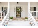 Welcoming front porch with decorative wreath, flower pots and house number at 220 New Oak Ln, Moncks Corner, SC 29461