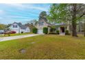 View of home and yard with solar panels on roof; detached garage in the background at 234 Lipman St, Summerville, SC 29483