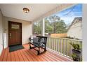 Inviting front porch with black bench, wood flooring, and view of the backyard at 234 Lipman St, Summerville, SC 29483