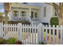 Inviting front entrance of a home featuring a well-manicured lawn, white picket fence, and a charming covered porch at 2681 Park West Blvd, Mount Pleasant, SC 29466