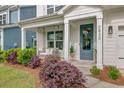 Inviting front porch featuring a swing, stylish blue door, and lush landscaping for curb appeal at 2830 Backman St, Mount Pleasant, SC 29466