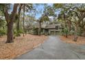 Charming home featuring a two-car garage and lush landscaping with mature trees, creating a private and inviting atmosphere at 3110 Up Da Creek Ct, Seabrook Island, SC 29455