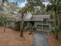 Charming home featuring a two-car garage and lush landscaping with mature trees, creating a private and inviting atmosphere at 3110 Up Da Creek Ct, Seabrook Island, SC 29455