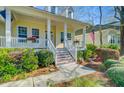 Welcoming front porch with white columns, wooden stairs, decorative flower boxes, and an American flag at 3447 Toomer Kiln Cir, Mount Pleasant, SC 29466