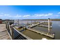 Scenic view of a marina featuring wooden docks, moored boats, and calm river waters under a cloudy sky at 3701 Dock Site Rd # 302, Edisto Beach, SC 29438