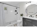 Modern bathroom featuring a sleek vanity, round mirror, and a stylish shower with black fixtures at 4757 June St, North Charleston, SC 29405