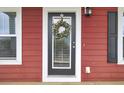 Welcoming front door with glass panel, surrounded by sidelights, wreath, and light fixture at 490 Sanders Farm Ln, Charleston, SC 29492