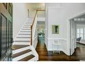 Bright foyer features hardwood floors, staircase, and entry to adjacent rooms at 5254 Mulholland Dr, Summerville, SC 29485