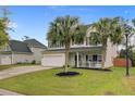 Two-story home with lush lawn, palm trees, and a two-car garage at 5254 Mulholland Dr, Summerville, SC 29485