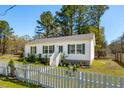 Inviting single-story home featuring a well-maintained lawn and classic white picket fence at 5638 Dixie Plantation Rd, Hollywood, SC 29449