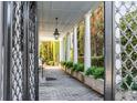 A brick walkway with manicured greenery leads to a white columned portico and the main entrance at 61 Tradd St, Charleston, SC 29401