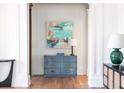 Stylish hallway with hardwood floors, white trim, and a charming blue accent cabinet at 772 Post Oak Dr, Mount Pleasant, SC 29464