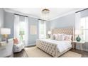 Serene main bedroom with tufted headboard, chandelier, and large windows with natural light at 780 Clay Field Trl, Summerville, SC 29485