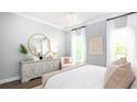 The main bedroom features soft colors, large windows, a chandelier, and an elegant dresser at 780 Clay Field Trl, Summerville, SC 29485