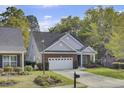 Charming brick home with a well-manicured lawn, two-car garage, and lush trees at 102 Brutus Ln, Summerville, SC 29485