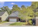 Charming brick home with a well-manicured lawn, two-car garage, and lush trees at 102 Brutus Ln, Summerville, SC 29485