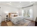Bright bedroom with a plush bed, tray ceiling, and large windows offering a serene view at 1020 Sagegrass St, Summerville, SC 29485