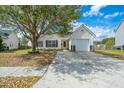 Single-story home with attached garage, mature tree, and well-maintained lawn and driveway at 104 Cranston Ln, Summerville, SC 29483