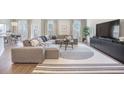 Bright living room featuring a modern sectional, stylish rug, and large windows providing natural light at 1132 Mossy Rock Dr, Summerville, SC 29485