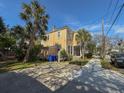 Two-story home with a porch, yellow siding, and palm trees in a well-maintained yard at 125 Ashley Ave, Charleston, SC 29401