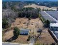 Aerial view of a single Gathering home and lot with mature trees and a large yard in an industrial area at 126 N Hwy 52, Moncks Corner, SC 29461