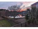 Scenic backyard view featuring a serene lake at sunset and mature trees at 138 Sandshell Dr, Charleston, SC 29492