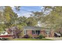 Charming brick home with a well-maintained lawn, mature trees, and classic black window shutters at 1406 Iroquois St, North Charleston, SC 29405
