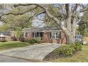 Inviting brick home with mature landscaping, classic black shutters, and a spacious driveway at 1406 Iroquois St, North Charleston, SC 29405