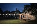 Backyard at night featuring a fire pit and swing illuminated with string lights at 1433 Oakhurst Dr, Mount Pleasant, SC 29466